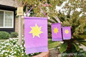 Three purple flag banner decorations for a Tangled themed birthday party.
